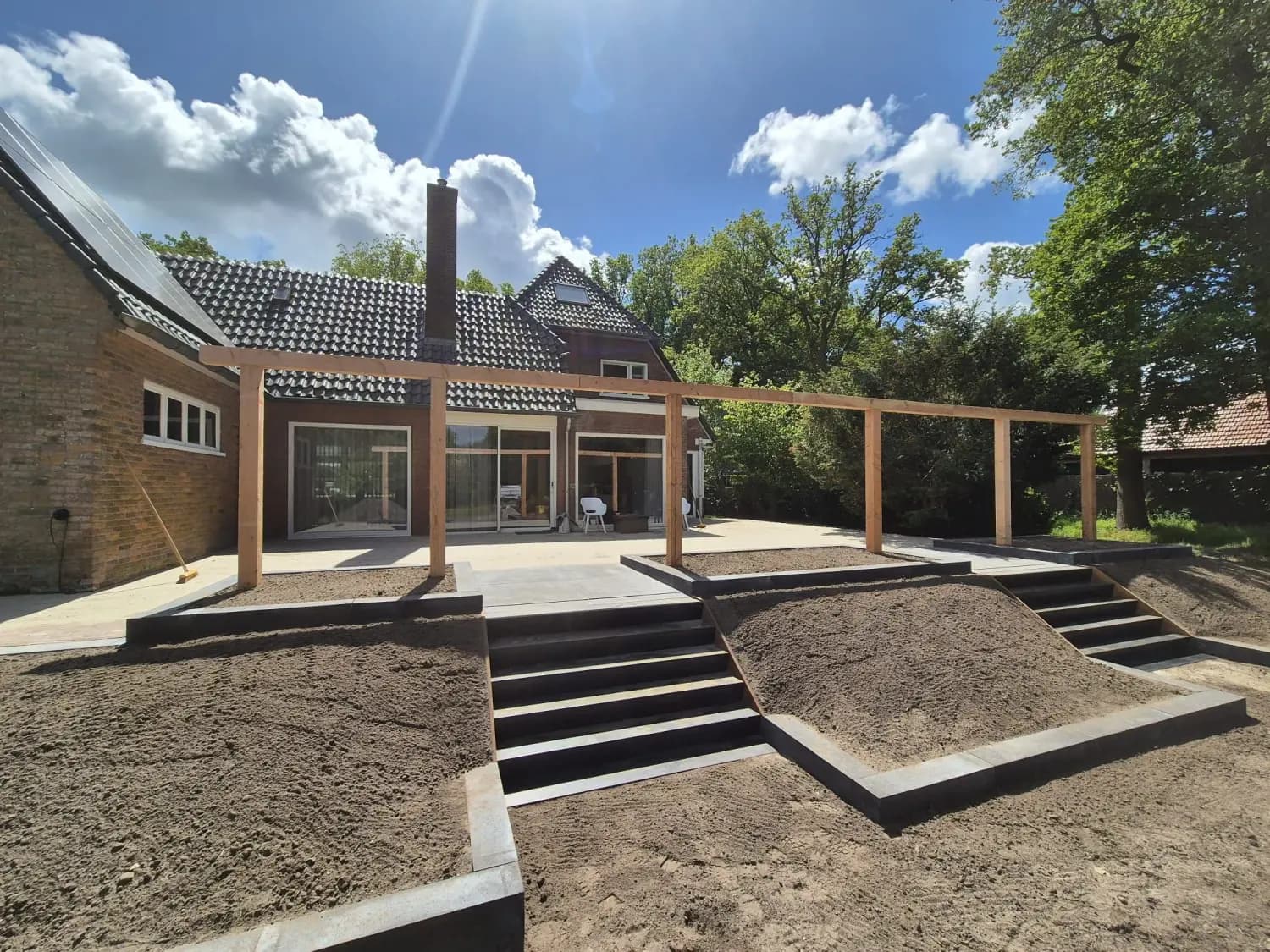 Tuinrenovatie in Oldeberkoop met verhoogd terras, cortenstalen trap en pergola van douglashout