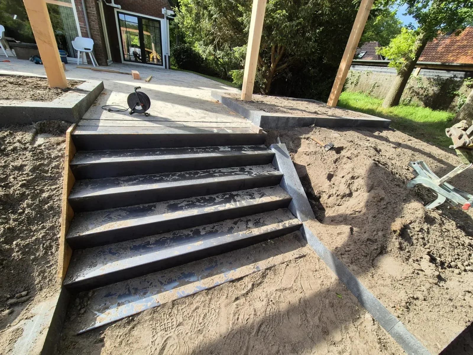 Zandbed met de nieuwe trap achter een woning in Oldeberkoop, voor de aanleg van het terras