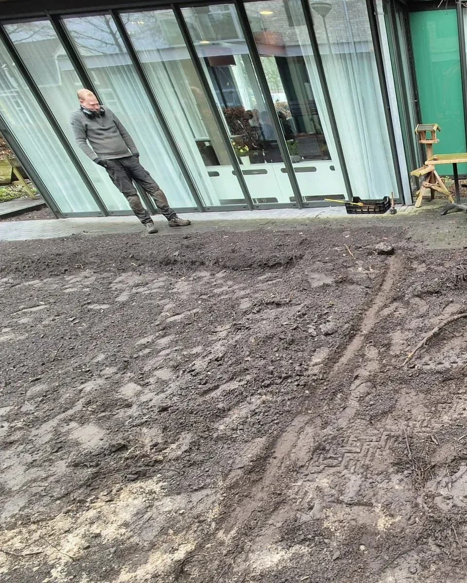 Omgewoelde grond voor de gevel van zorglocatie Voltawerk in Gorredijk, aan het begin van de aanleg van de belevingstuin